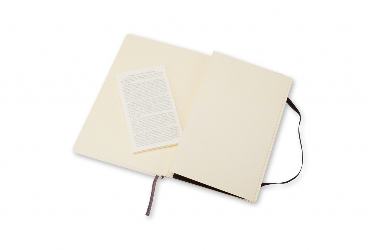 Atversta juoda Moleskine 9 × 14 cm knygutė su tuščiais kreminiais lapais, tekstiniu lankstinuku ir juoda guma