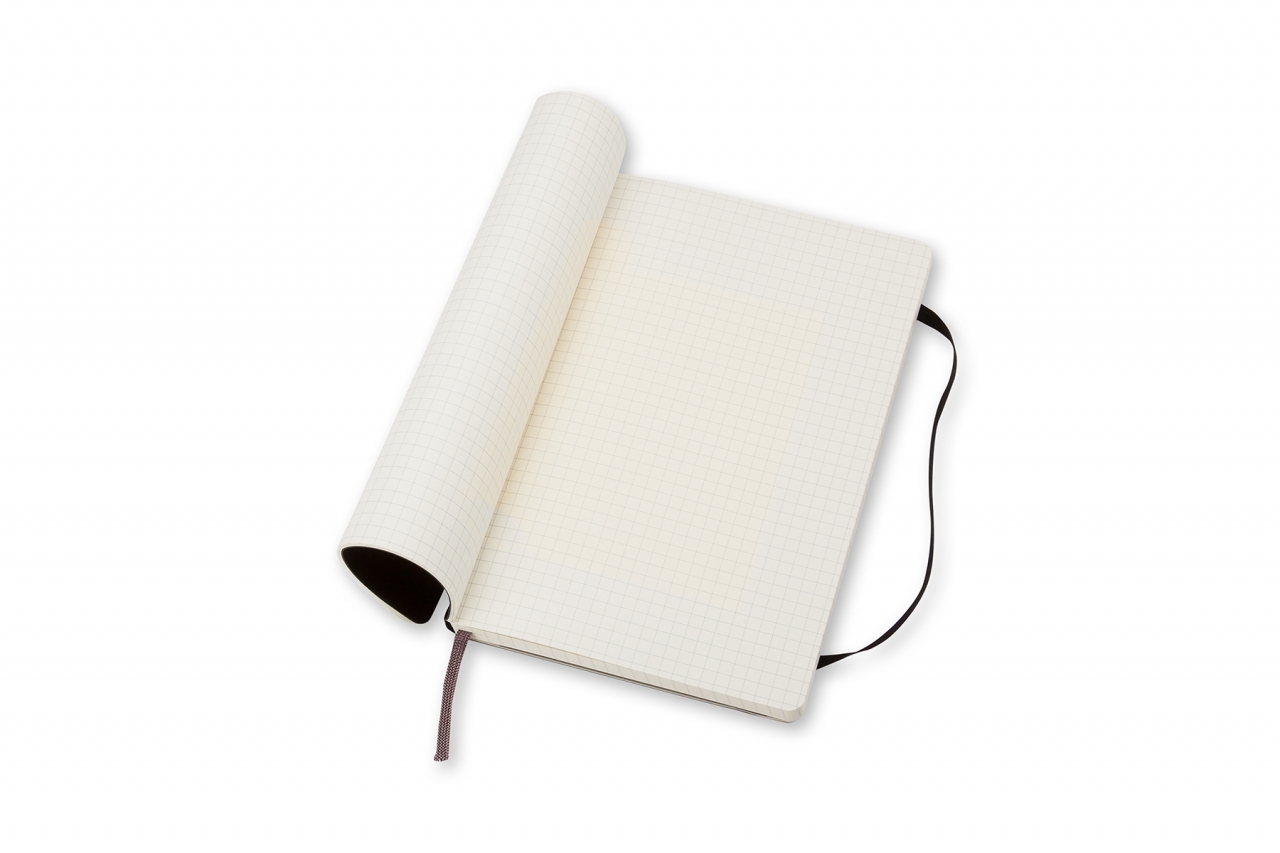 Atversta juoda Moleskine knygutė su kreminiais languotais puslapiais, skirtuku ir elastine juosta