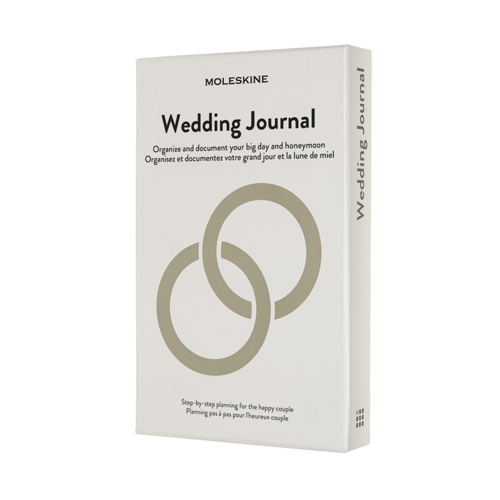 Balta Moleskine Wedding Journal dėžutė su juodu pavadinimu ir dviem dideliais persidengiančiais smėlio spalvos žiedais